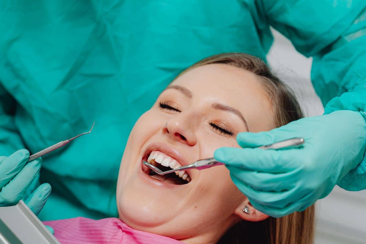 Dentista examinando a paciente sonriente.